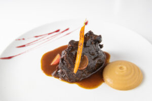 Plato gourmet de carne con salsa y puré en un restaurante