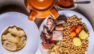 Plato de cocido con garbanzos, carnes y sopa en la Taberna Ansorena