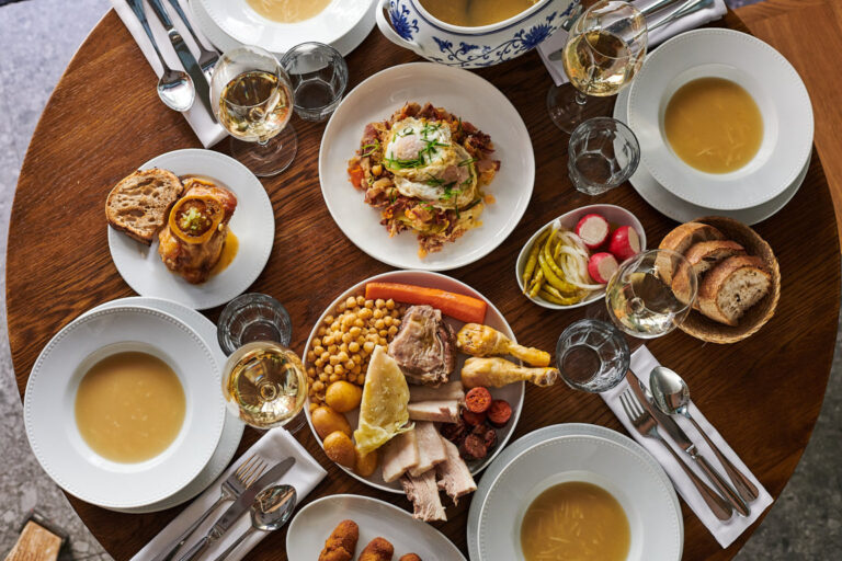 Mesa con cocido madrileño y platos variados en La Cocina de Frente.