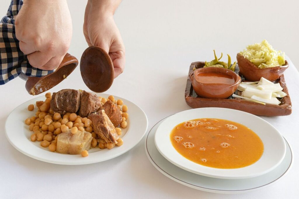 Plato de cocido madrileño servido con garbanzos y carne.