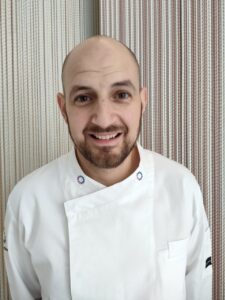 Chef sonriente en un entorno moderno y acogedor.
