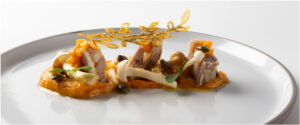 Plato de cordero escabechado con puré de calabaza y decoraciones