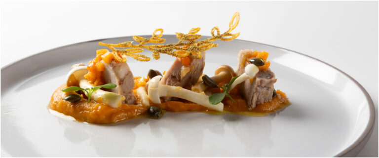 Plato de cordero escabechado con puré de calabaza y decoraciones