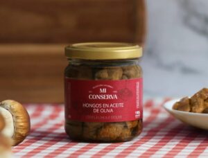 Tarro de hongos en aceite de oliva de Mi Conserva sobre una mesa.