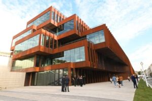 Edificio moderno de GOe con personas en la entrada durante la inauguración.