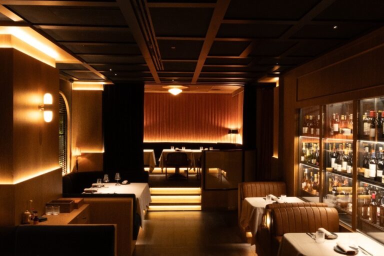 Interior del restaurante Noble en Valencia con iluminación cálida y mesas elegantes.