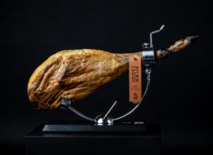 Jamón de alta gastronomía presentado en un soporte elegante