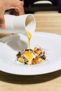 Plato gourmet con salsa vertida en un restaurante de La Rioja.