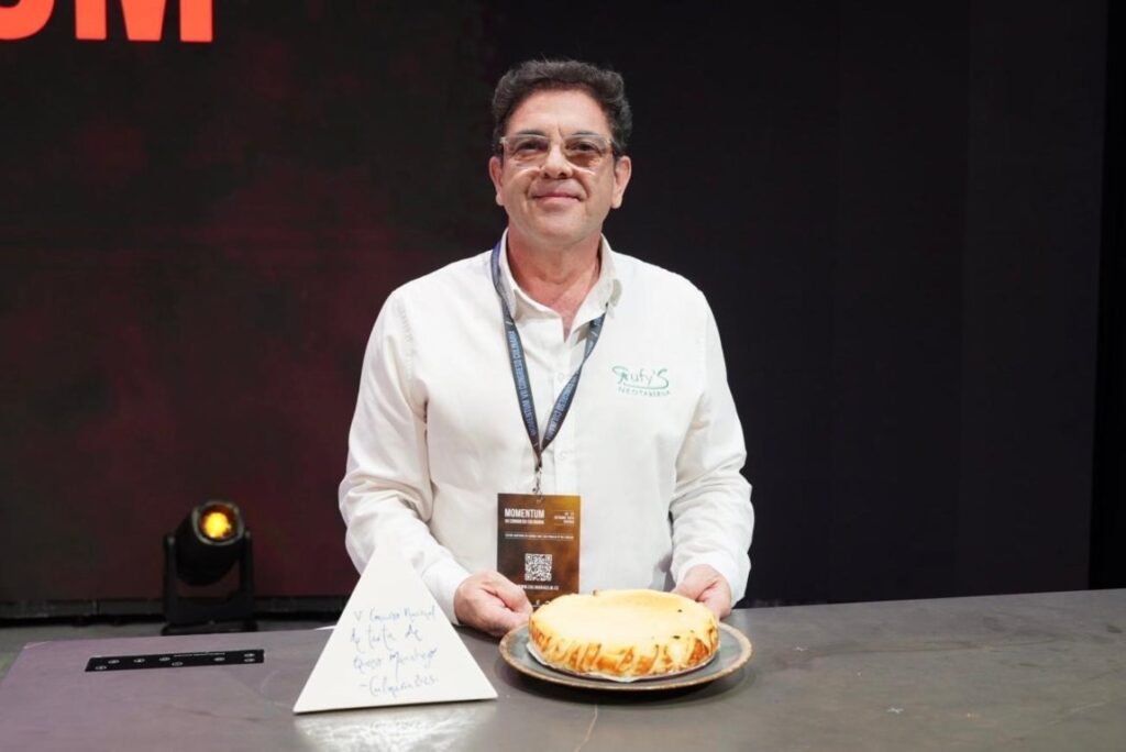 Rufino Ruiz sosteniendo su tarta de queso manchego ganadora en un concurso