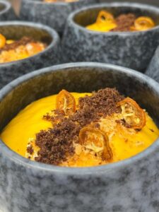 Salmorejo de naranja presentado en un recipiente moderno con decoraciones