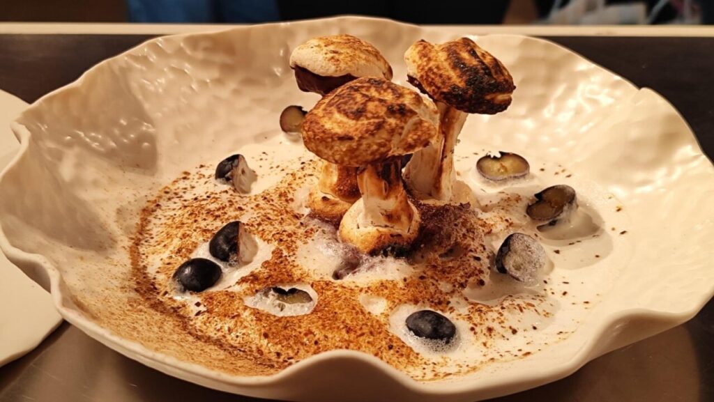 Plato gourmet con setas y espuma en congreso gastronómico