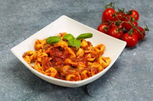 Tortellini de mortadella con salsa de tomate y albahaca fresca