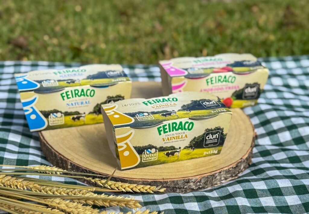Tres yogures Feiraco de sabores natural, vainilla y fresa sobre una tabla de madera.