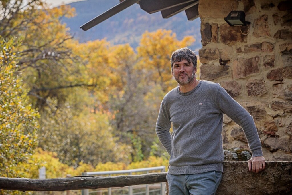Óscar García en un entorno natural con árboles de otoño