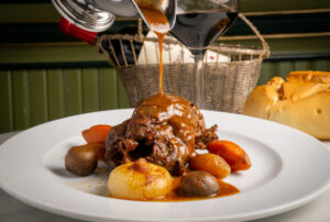 Perdiz estofada servida con verduras en Casa Duque, Segovia.