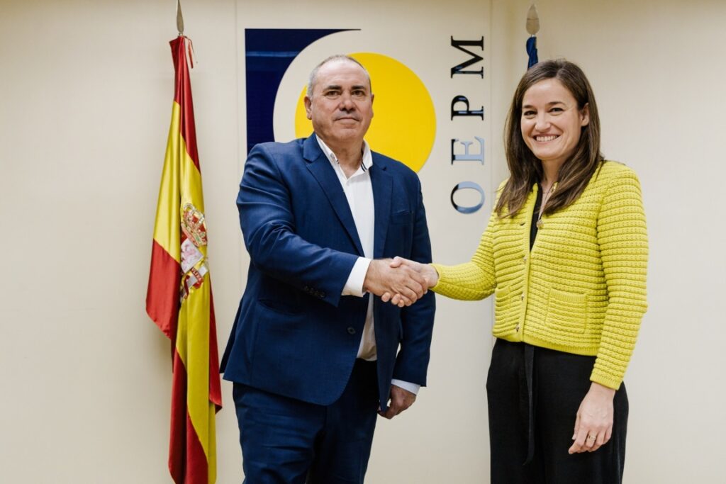 Dos personas estrechando manos durante la firma de un convenio de colaboración.
