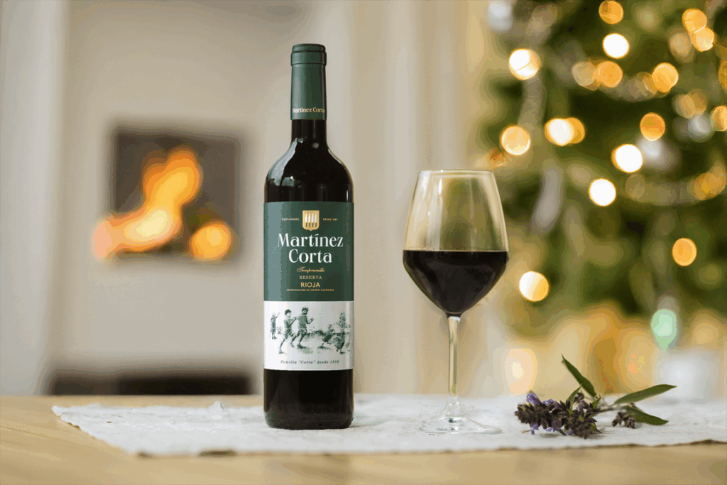 Botella de vino Martínez Corta Reserva con copa y decoración navideña