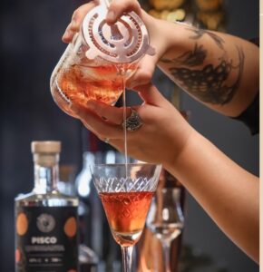 Preparación de un cóctel con pisco en un bar