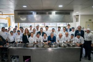 Grupo de chefs en cocina colaborando para raciones solidarias