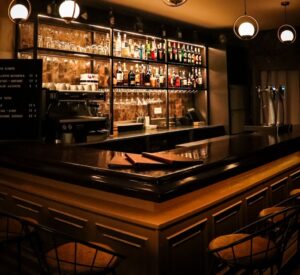 Interior del bar Allégorie con barra y estantes de bebidas