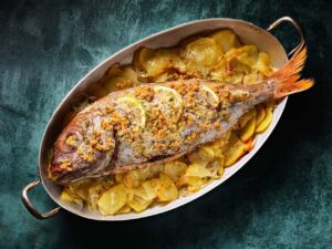 Besugo al horno con patatas y limón, plato navideño tradicional.