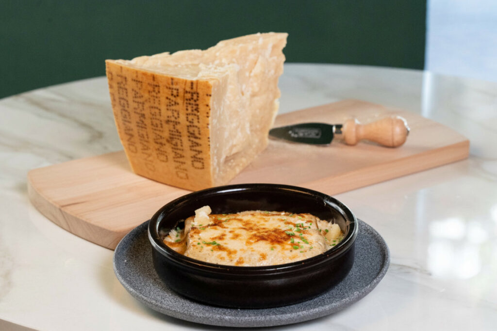 Canelones gratinados con Parmigiano Reggiano y pieza de queso.