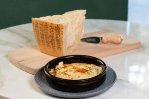 Canelones gratinados con Parmigiano Reggiano y pieza de queso.