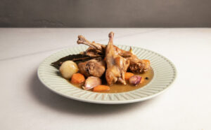 Plato de carne de conejo guisada con verduras y especias