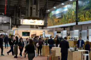 Visitantes en la feria de vino en Barcelona, con stands de bodegas.