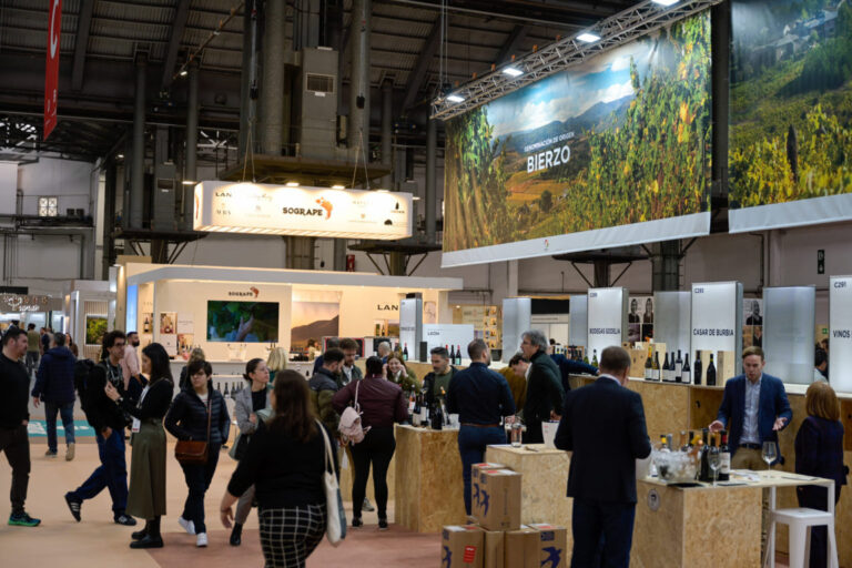 Visitantes en la feria de vino en Barcelona, con stands de bodegas.