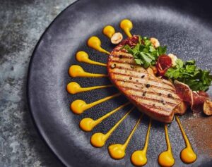 Plato de foie gras con salsas y decoración de hierbas