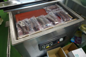 Embutidos artesanales envasados al vacío en una máquina.