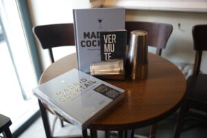 Libros sobre coctelería en una mesa de bar en Madrid