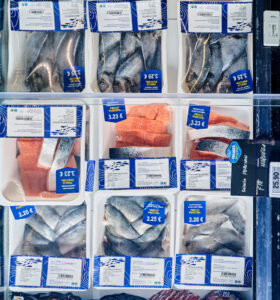 Variedad de pescado precortado en envases transparentes en un mostrador