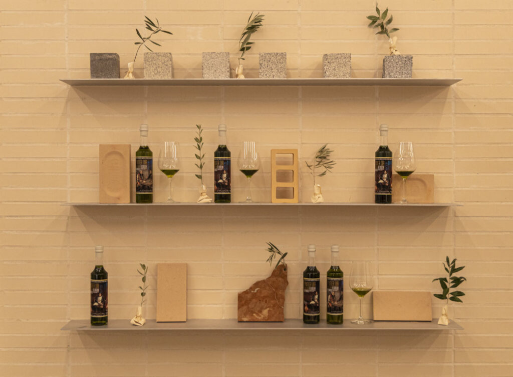 Botellas de aceite de oliva en estantería durante evento de Picualia