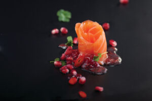 Salmón ahumado decorado con salsa de frambuesa y granada