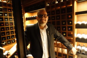 Santi Carrillo en una bodega con estantes de vino