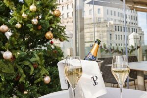 Decoración navideña con árbol y copas de champagne en azotea