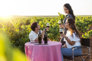 Tres personas brindando con vino en un viñedo de Extremadura