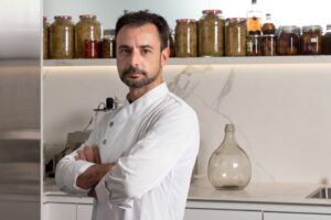 Chef Eduard Xatruch en su cocina, con frascos de ingredientes detrás.