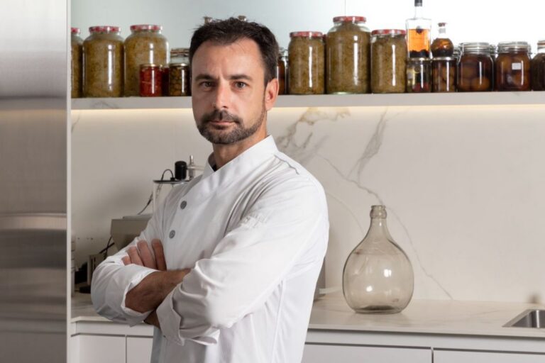 Chef Eduard Xatruch en su cocina, con frascos de ingredientes detrás.