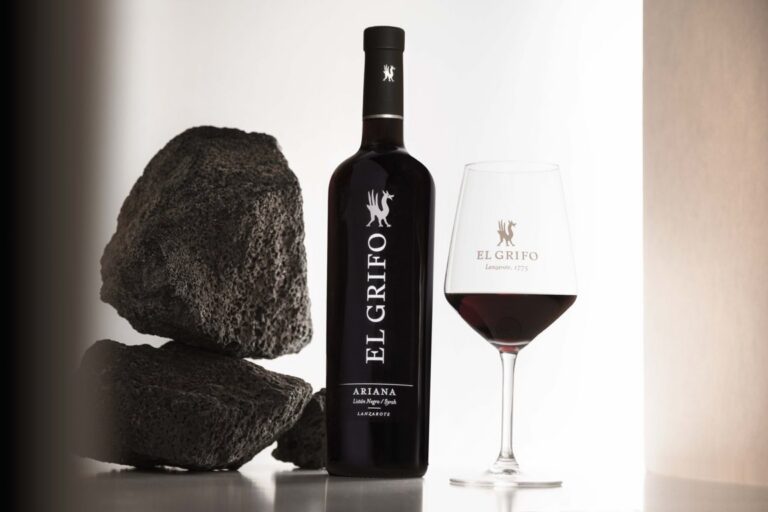 Botella de vino El Grifo Ariana 2024 junto a una copa y piedras volcánicas