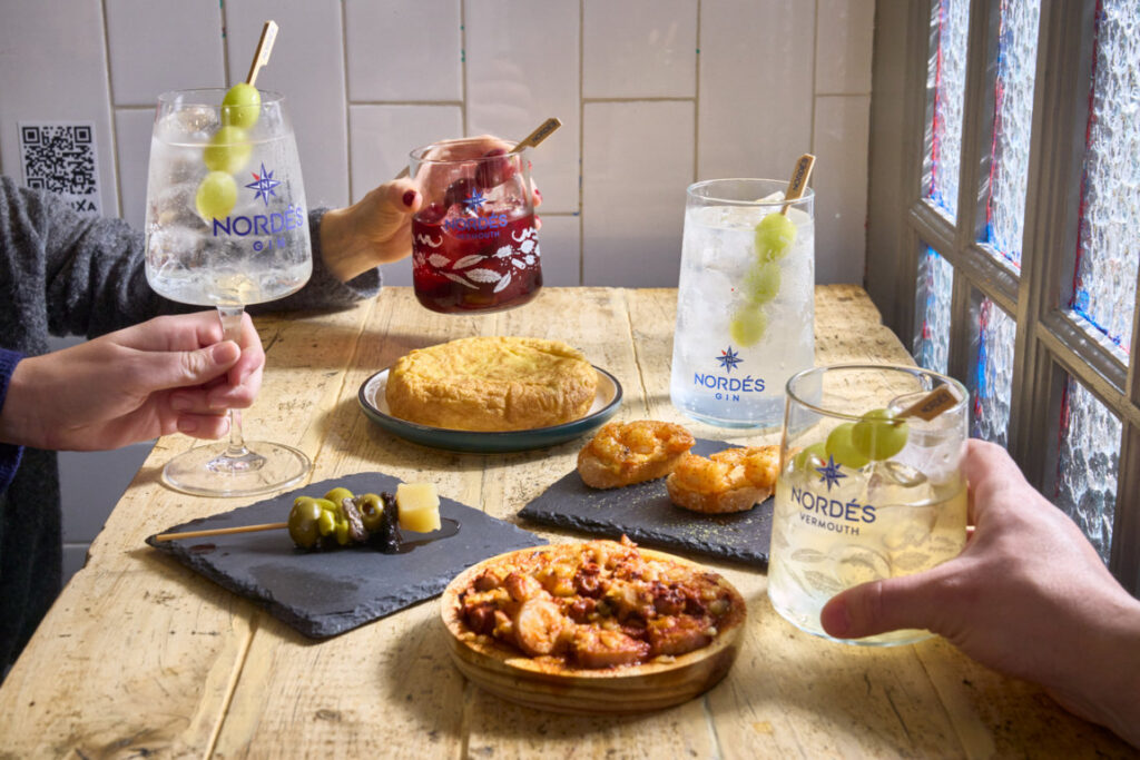 Mesa con tapas y bebidas de Nordés en un restaurante