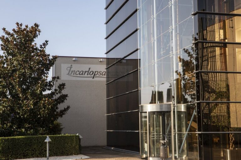 Fachada de la empresa Incarlopsa con vegetación y entrada principal