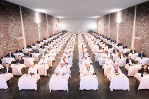 Ceremonia de premiación con jurados y mesas en un gran salón