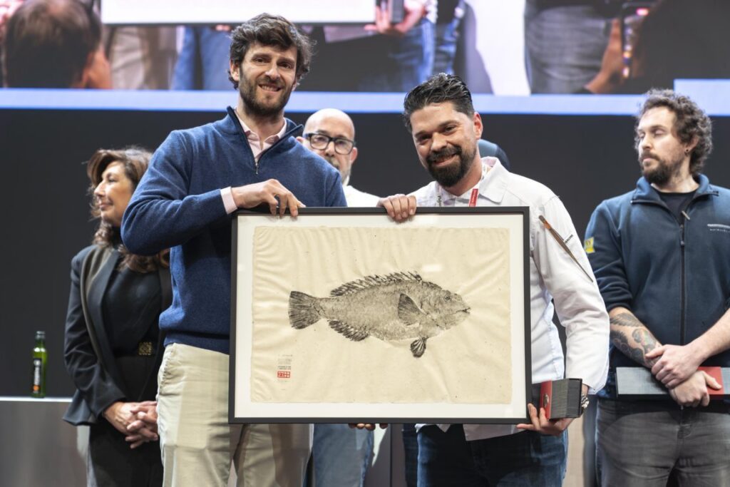 Luis Callealta sosteniendo un premio en un concurso de cocina