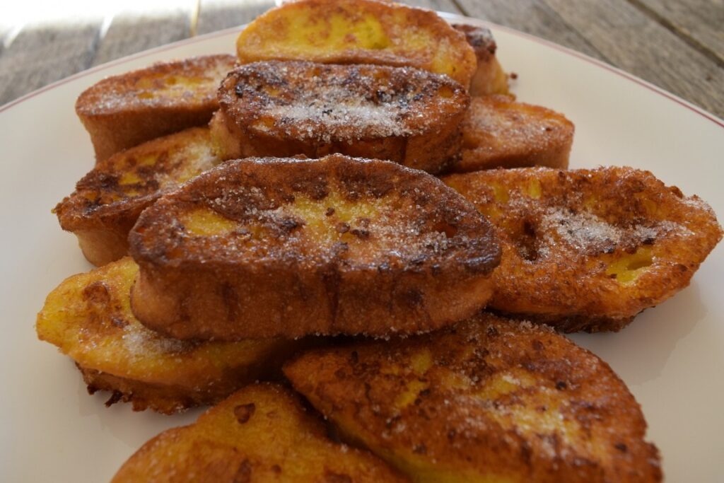 Torrijas doradas espolvoreadas con azúcar en un plato