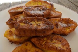 Torrijas doradas espolvoreadas con azúcar en un plato