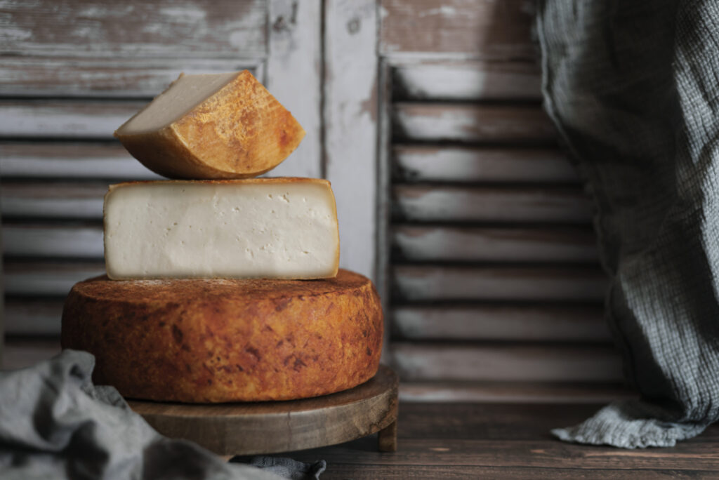 Tres tipos de queso de Gran Canaria apilados sobre una tabla de madera