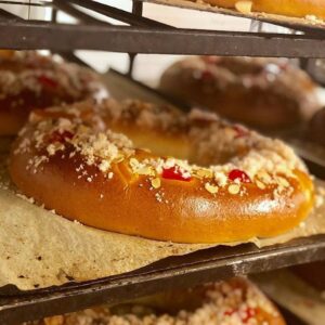 Roscón de Reyes artesano recién horneado con decoración de frutas y azúcar.